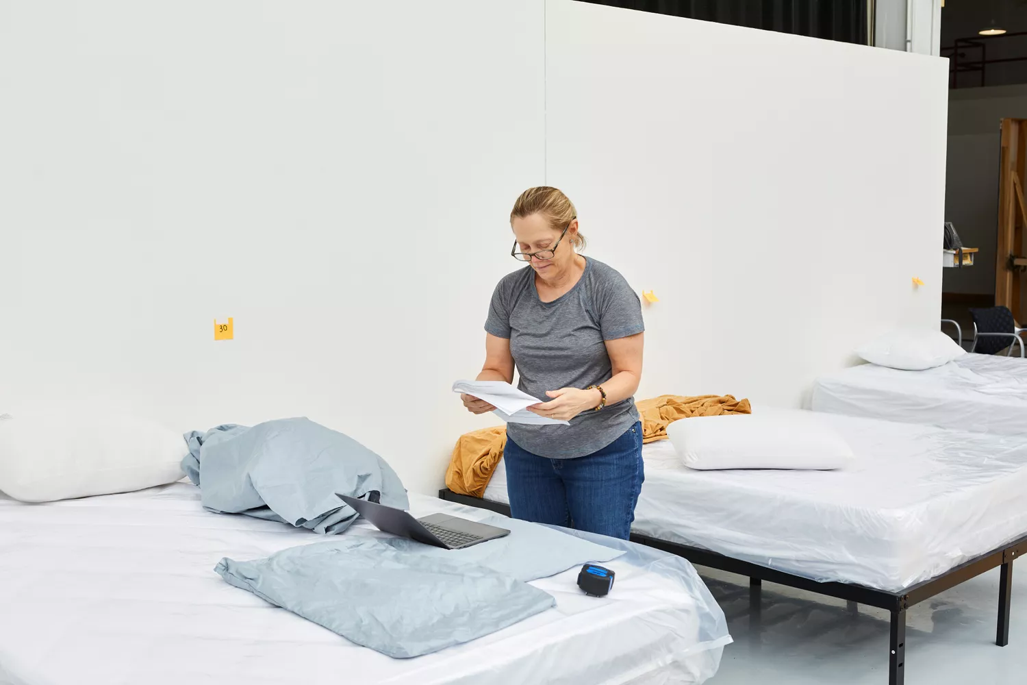 Woman reading instructions from Quince Luxury Organic Signature Set next to bed 