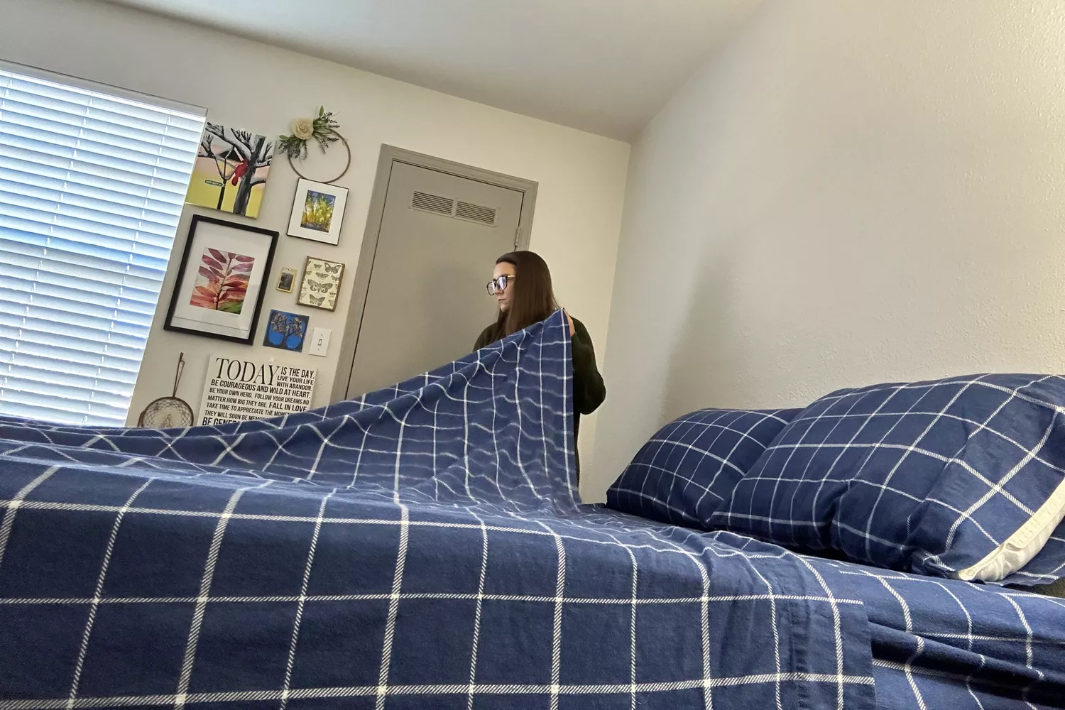 A person makes a bed using the Great Bay Home 100% Turkish Cotton Flannel Sheets Set
