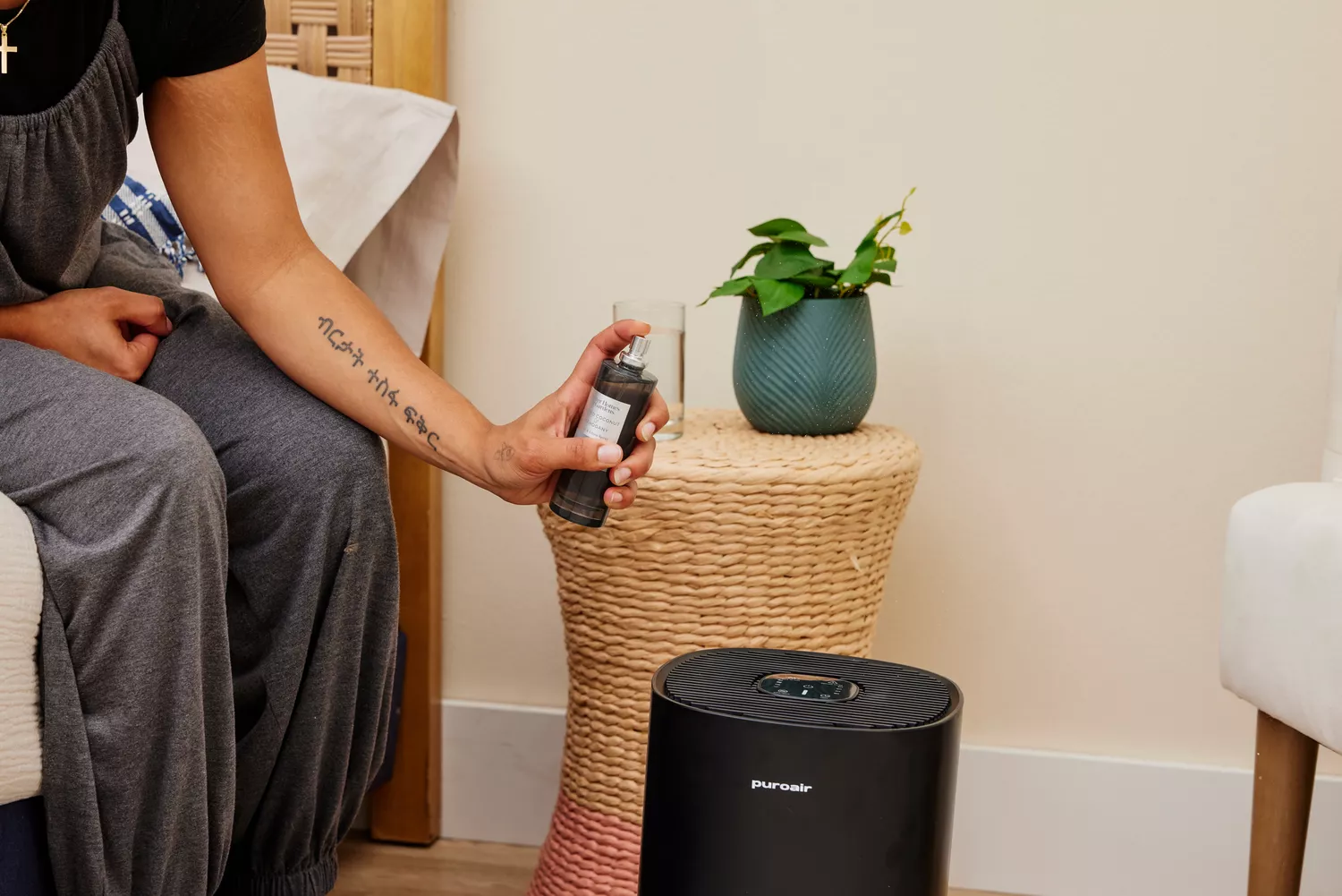 A person sprays perfume near the Puroair 240 Air Purifier