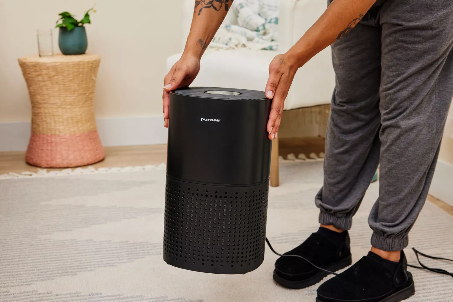 A person lifts up the Puroair 240 Air Purifier