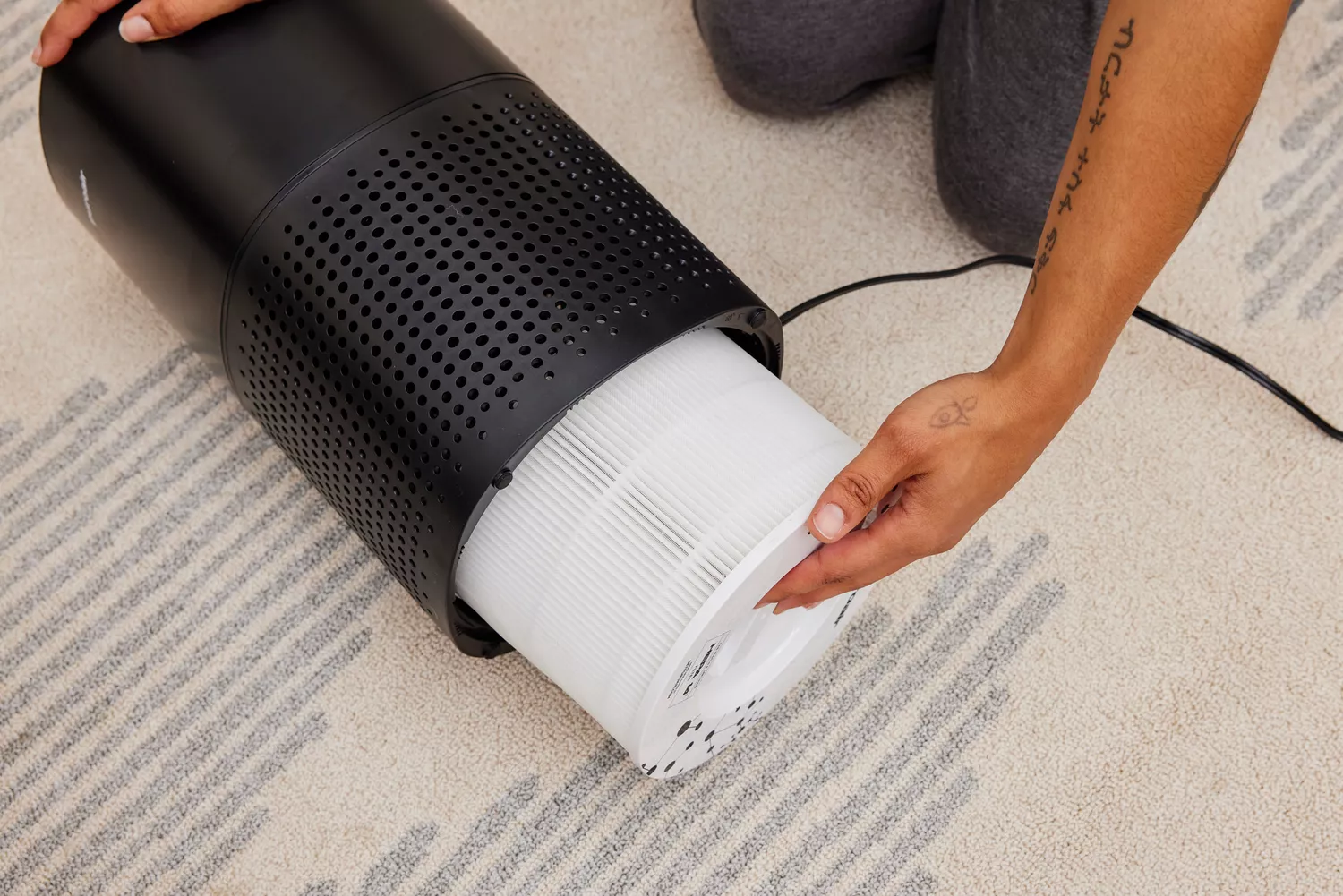 A person removes the filter on the Puroair 240 Air Purifier