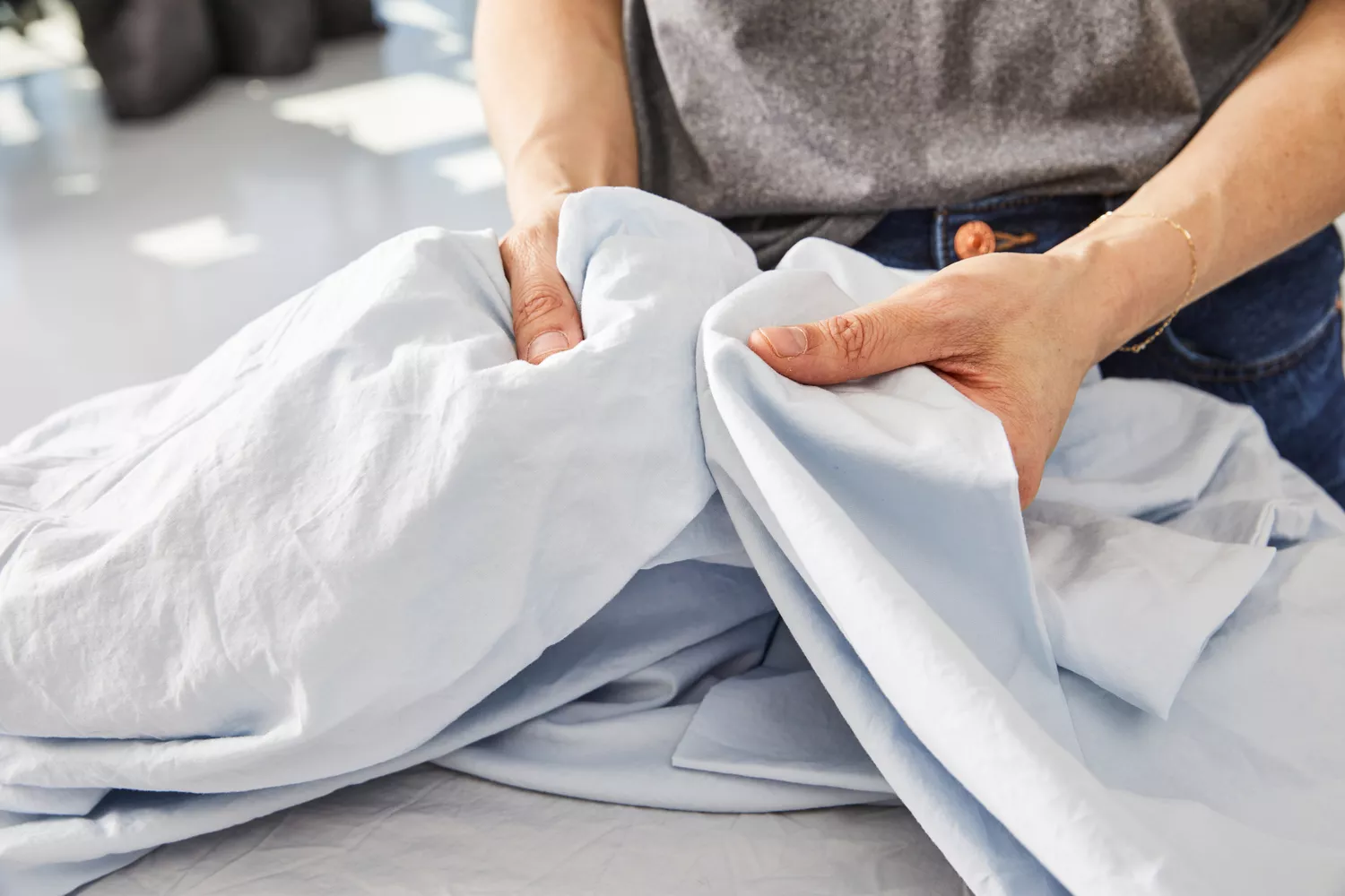 A person holds the Banana Republic Washed Cotton Percale Sheet Set