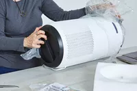Person removing the Levoit Core 400S Smart True HEPA Air Purifier from plastic