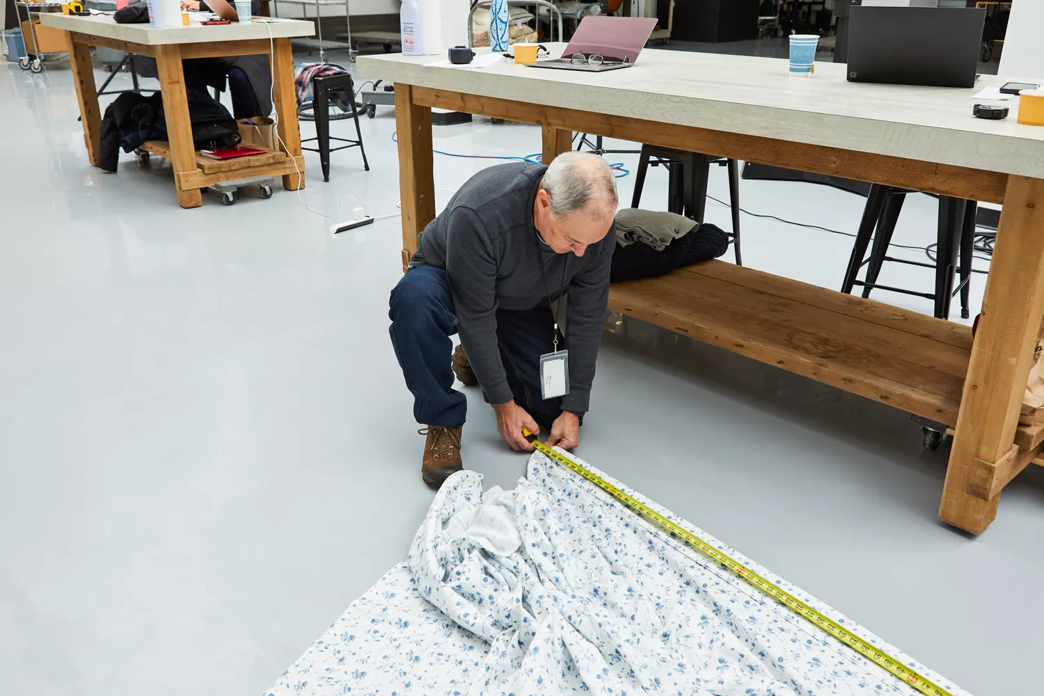 Person using measuring tape on the Threshold 400 Thread Count Printed Performance Sheet Set on the floor 