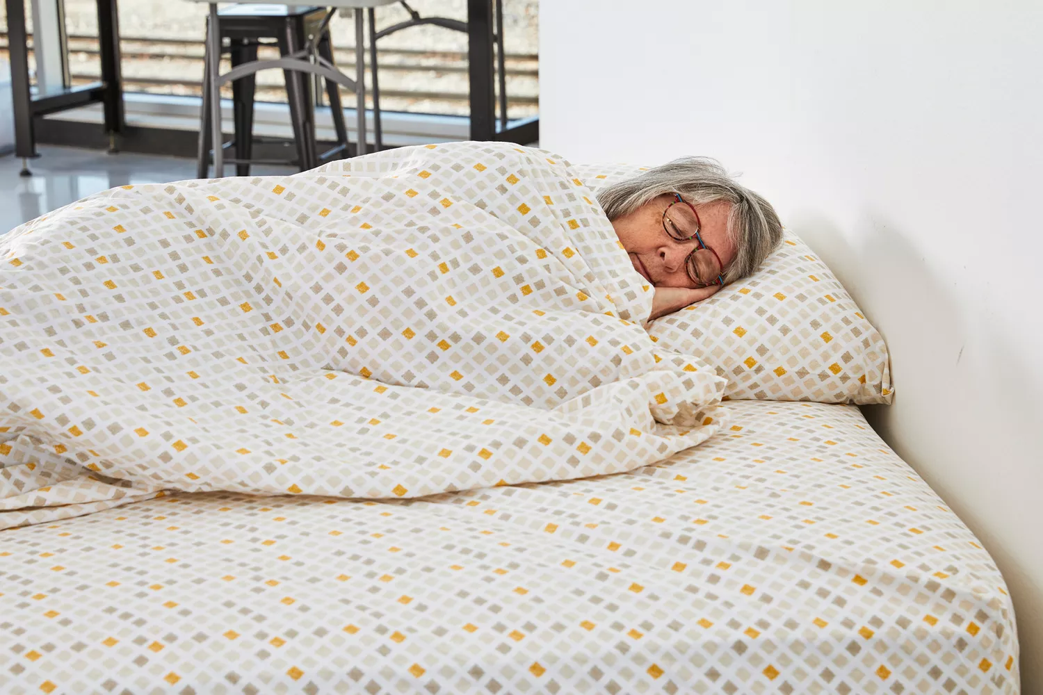 A person sleeping inside of the Feather & Stitch 100% Cotton Sheets