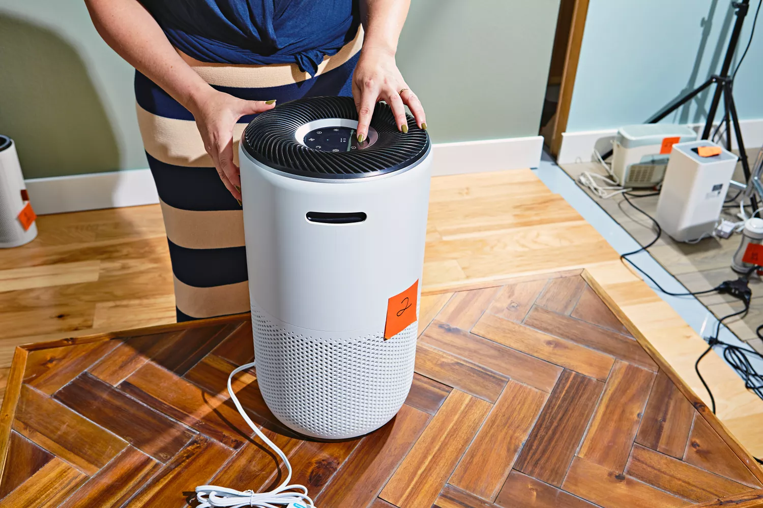 Person pushing button on top of the Levoit Core 400S Smart True HEPA Air Purifier