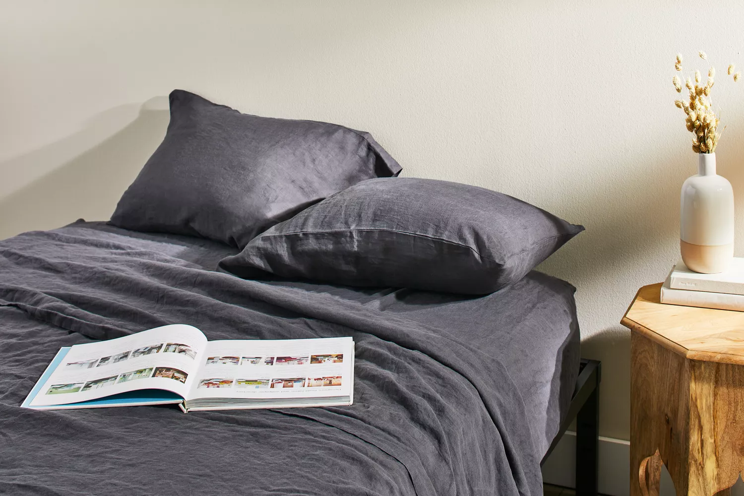 Quince European Linen Sheet Set displayed with pillows on mattress with an open book 