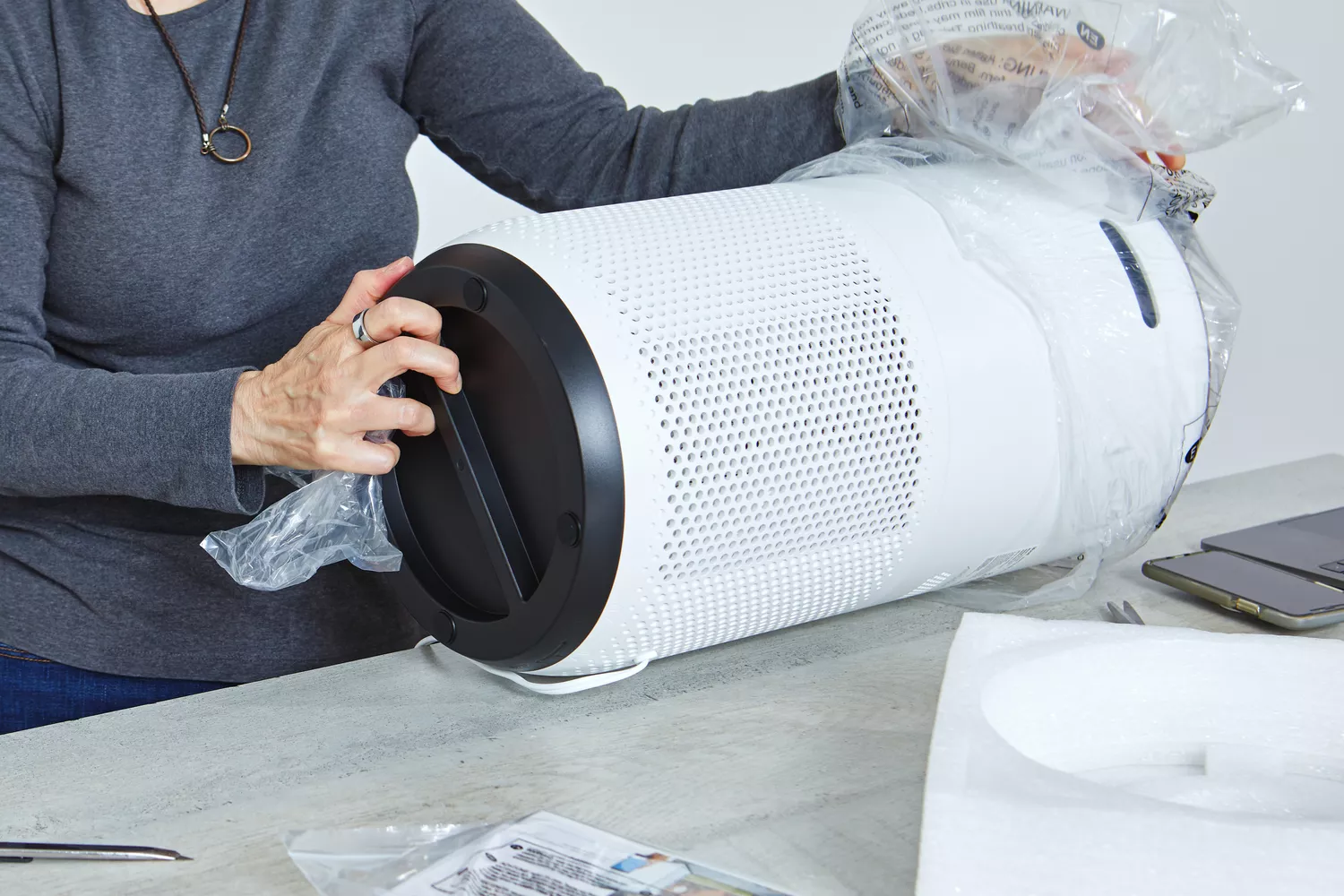 Person removing the Levoit Core 400S Smart True HEPA Air Purifier from plastic
