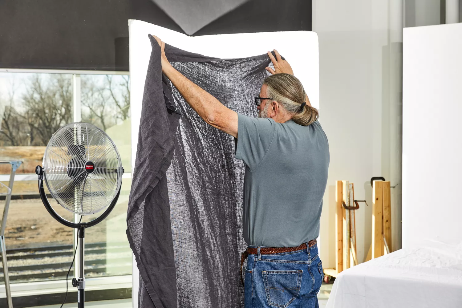 Person holding up a sheet from the Quince European Linen Sheet during testing