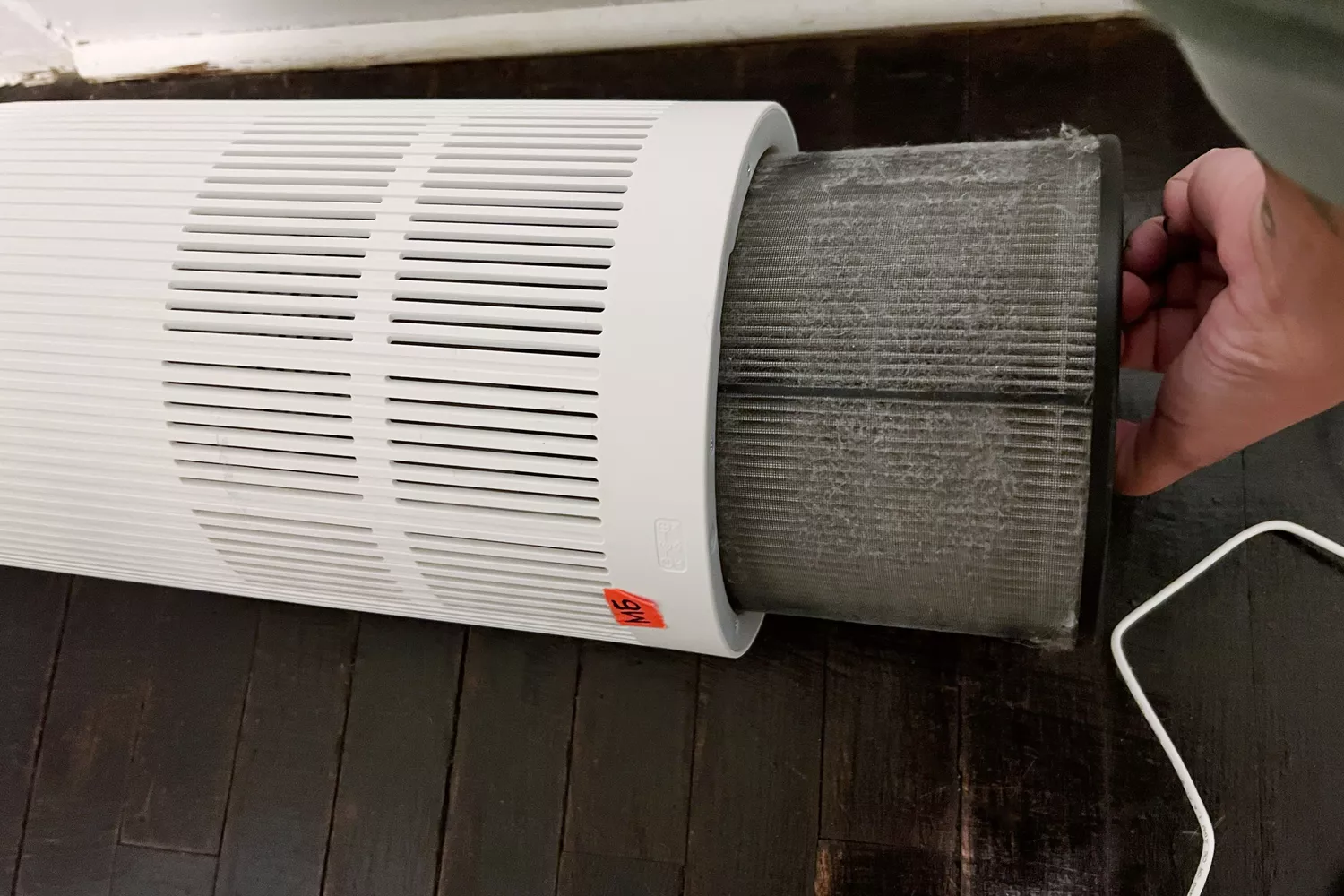 A person removes the filter from the Kenmore 850e Air Purifier