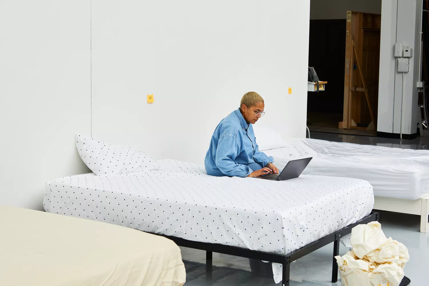 Person sitting on a bed with a laptop that is covered with a California Design Den Cotton Sateen Sheet Set