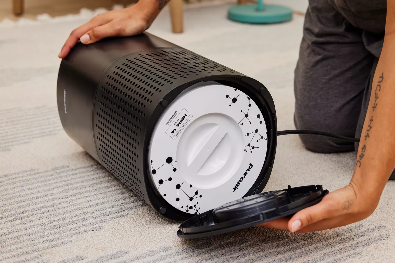 A person removes the filter cover on the Puroair 240 Air Purifier