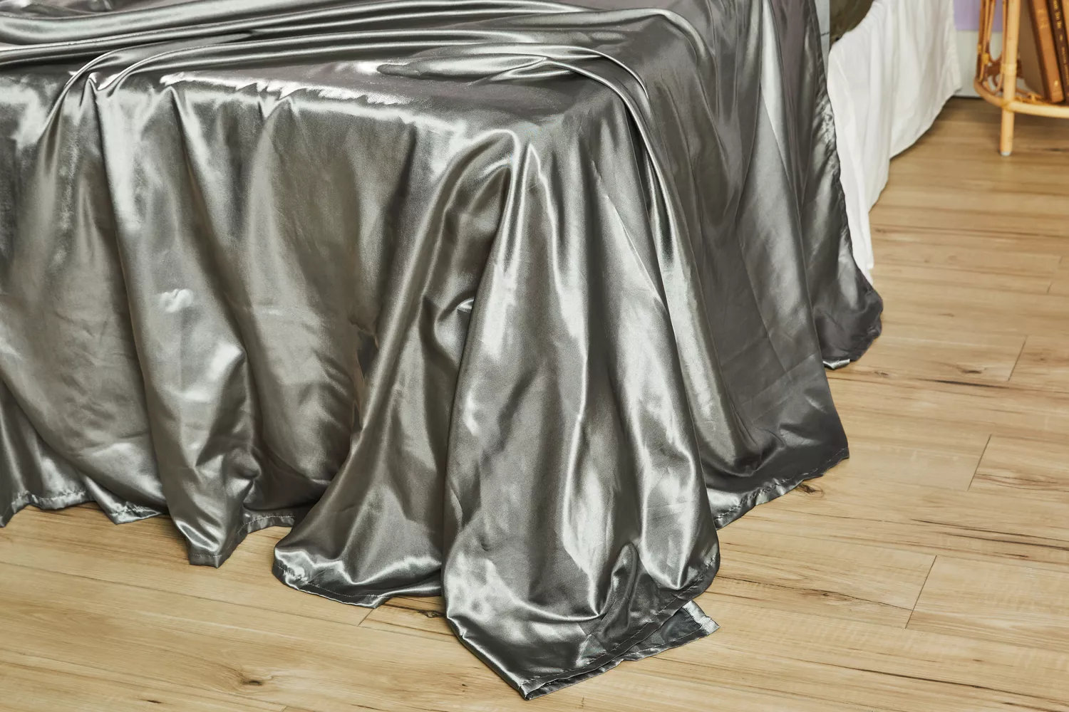 Lanest Housing Silk Satin Sheets are displayed on the bed while it touches the wooden floor