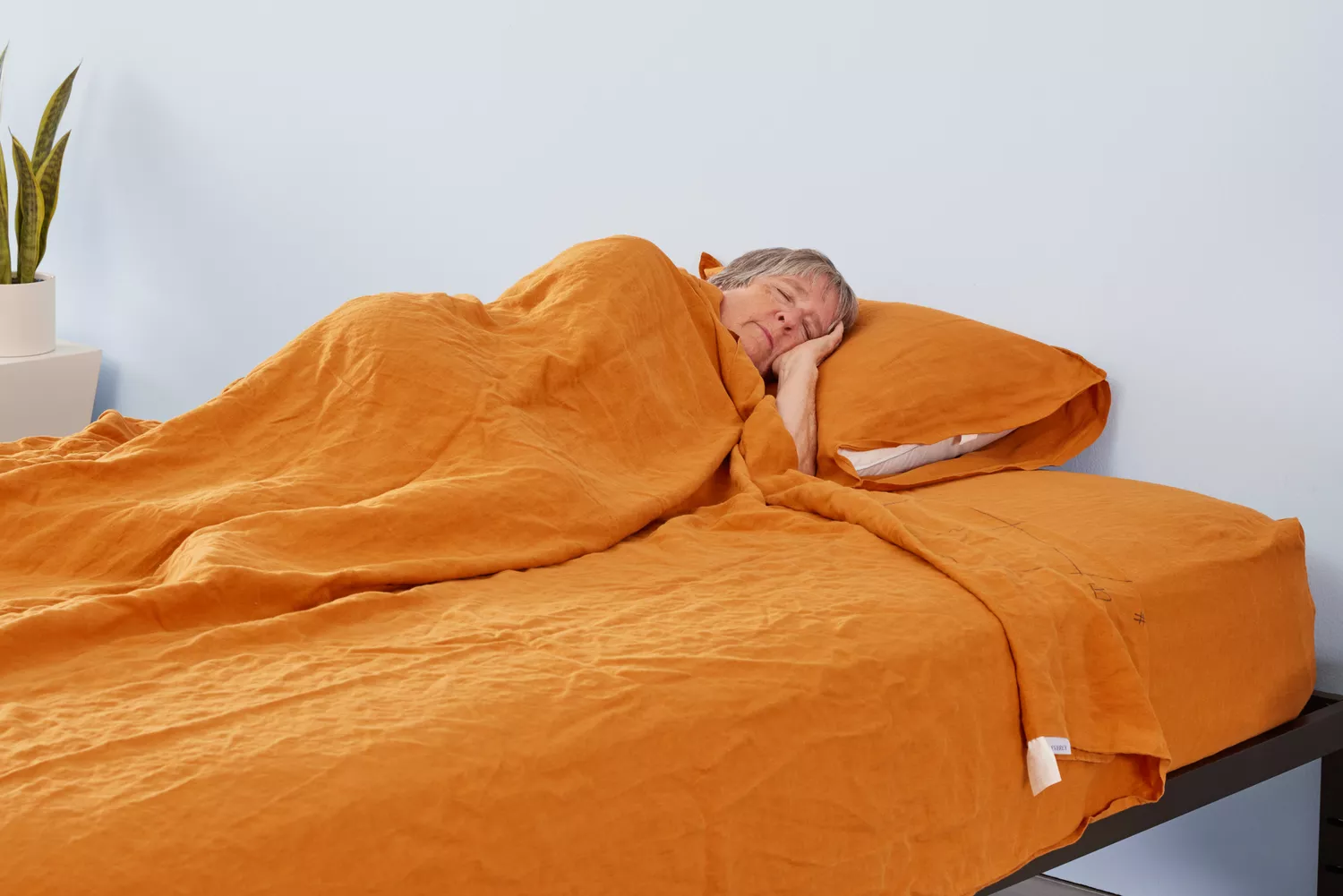 A person lies in the Everly Hemp Sheet Set