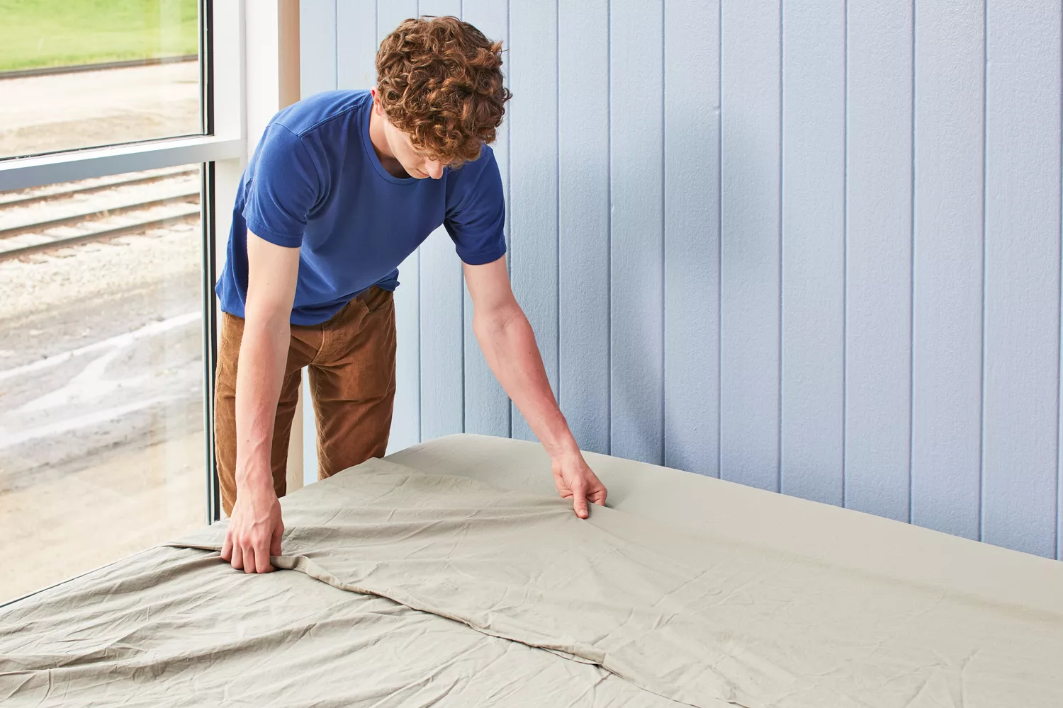 Person making a bed with the Parachute Percale Sheet Set