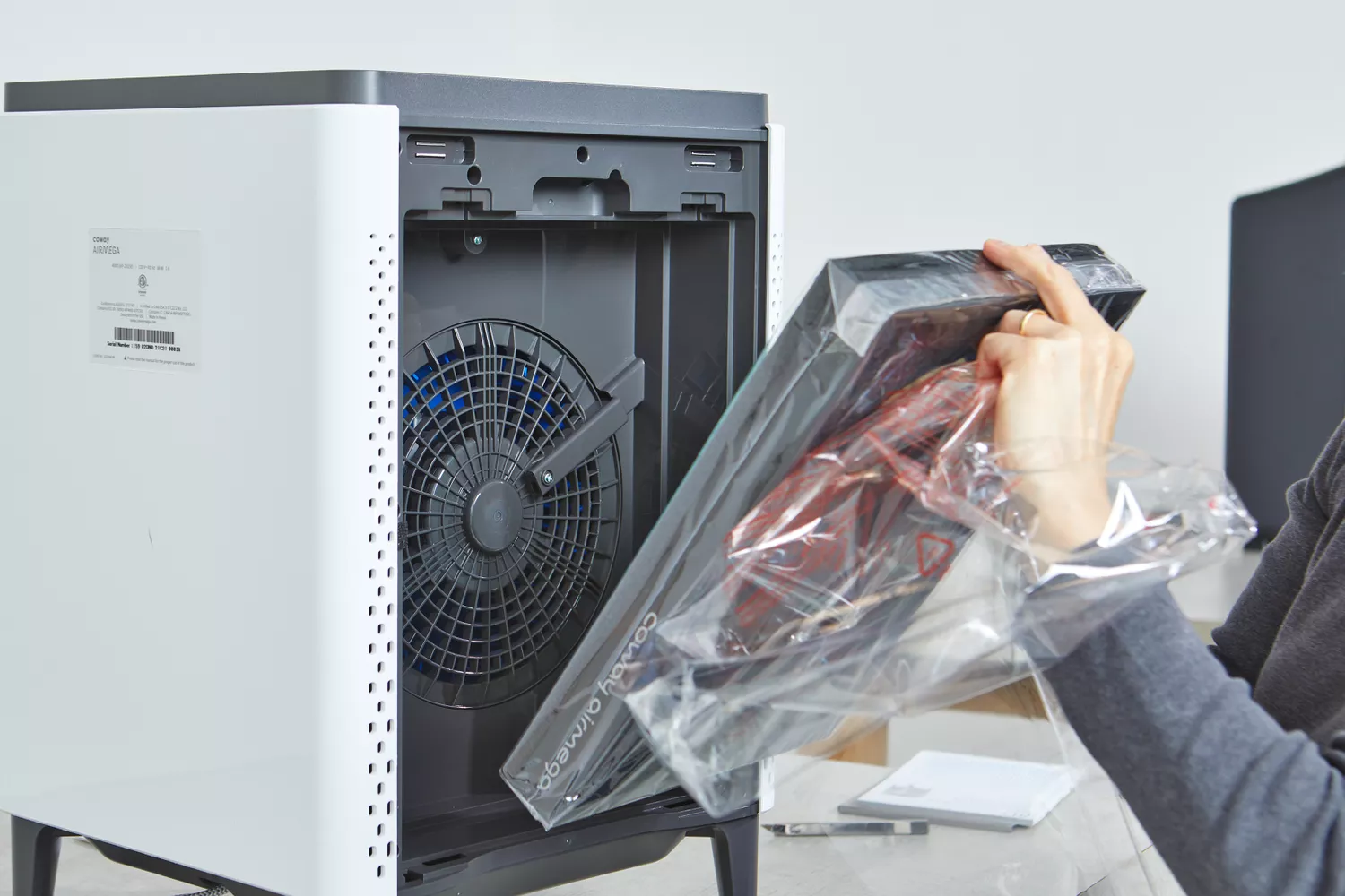 Person unwrapping part of Coway Airmega 400S Smart Air Purifier
