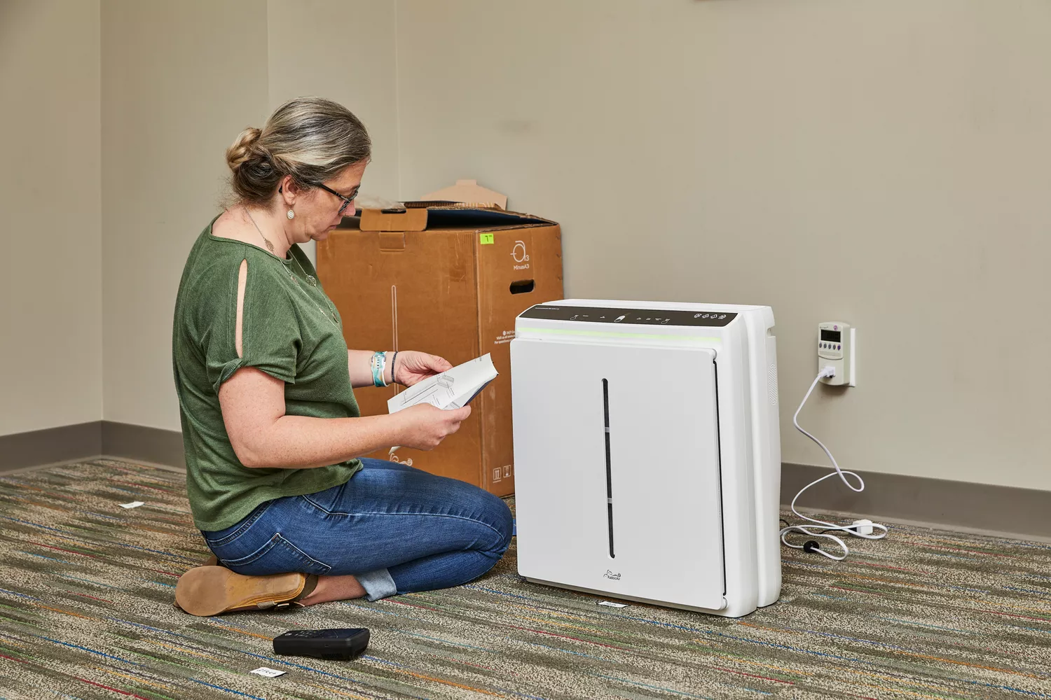 Person reading instructions manual of Rabbit Air A3 Ultra Quiet HEPA Air Purifier